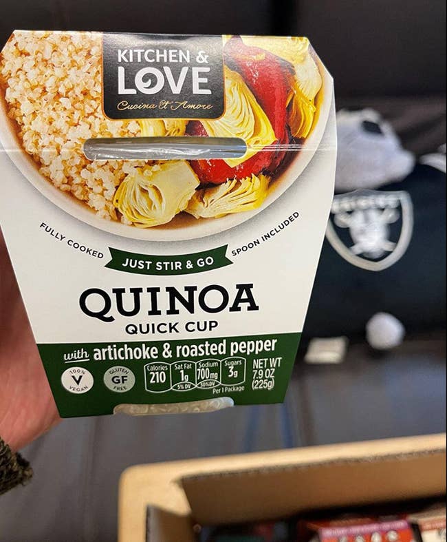 Reviewer holding up an artichoke and roasted pepper flavored quinoa cup 