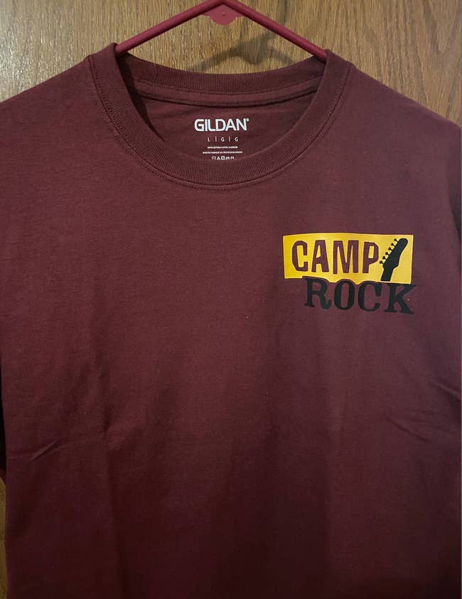 maroon colored t shirt with camp rock logo in the top right corner