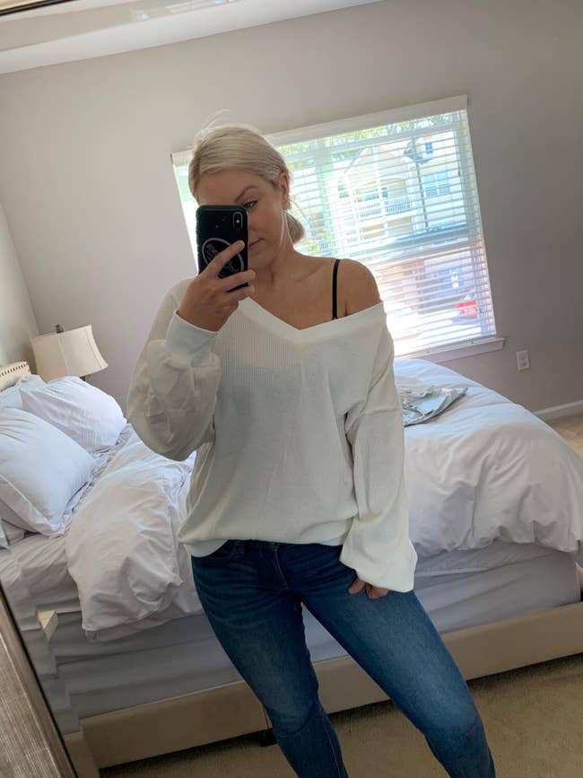 reviewer wearing the white v-neck sweater off the shoulder