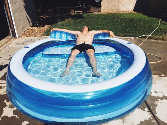 reviewer relaxing on the pool's built-in seat