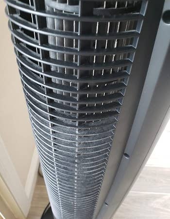 reviewer image of a standing fan that's half clean and half covered in dust
