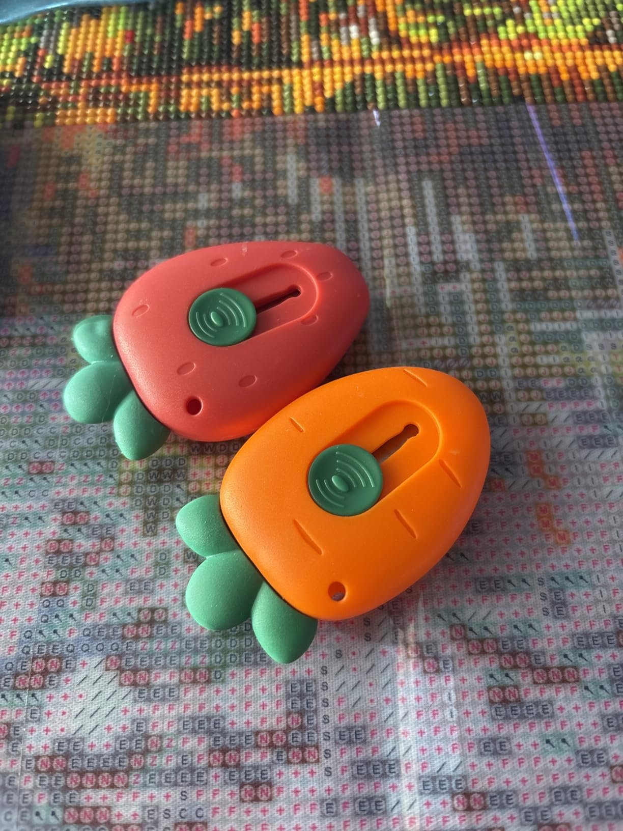 Two carrot-shaped stitch counters with greenish  leaves connected  a textured surface, utilized  successful  knitting and crochet projects