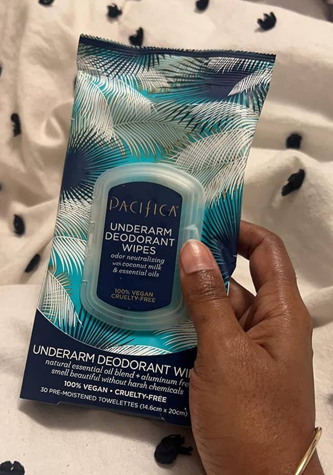 Hand holding a battalion of Pacifica underarm deodorant wipes