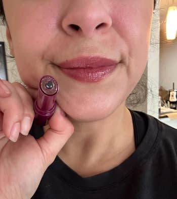Person applying lipstick, close-up connected  lips, holding a lipstick tube. Ideal for quality   oregon  makeup-focused buying  content