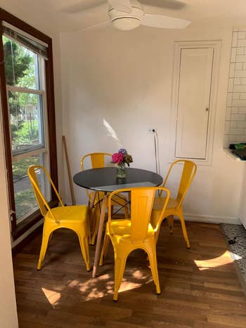 A reviewer's vivid dining field with a round table and four yellow chairs in a sunlit room, appropriate kind for dwelling decor inspiration