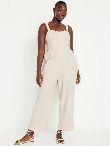 model in a sleeveless cream jumpsuit 