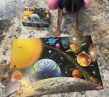 reviewer's child beside completed space puzzle