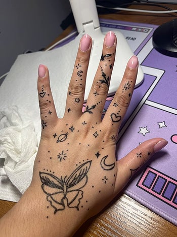 another reviewer photo of doodles on their hand made with the markers