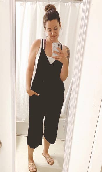 a reviewer wearing a spaghetti strap, V-neck jumpsuit in black 
