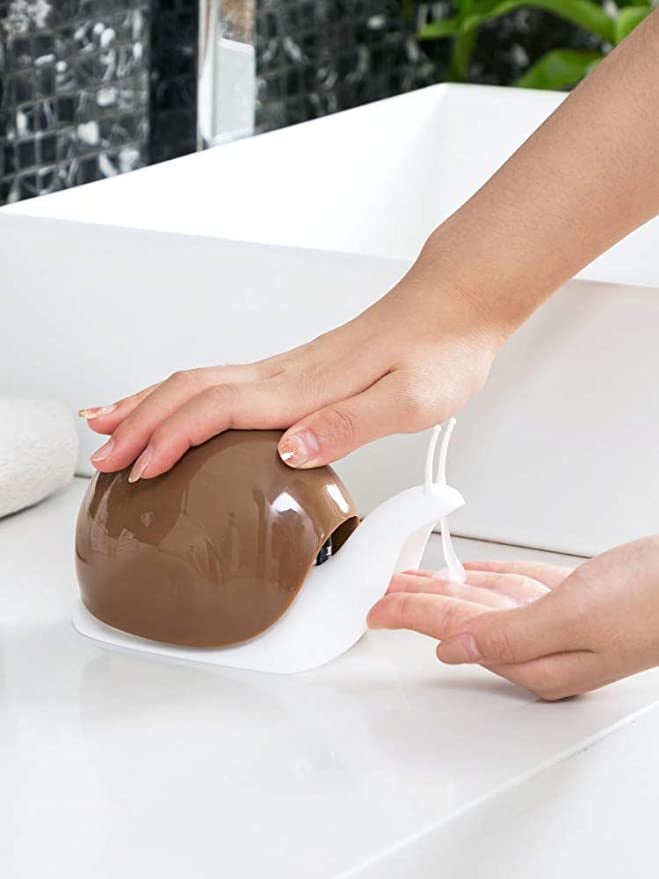 person pressing down on brown snail soap dispenser