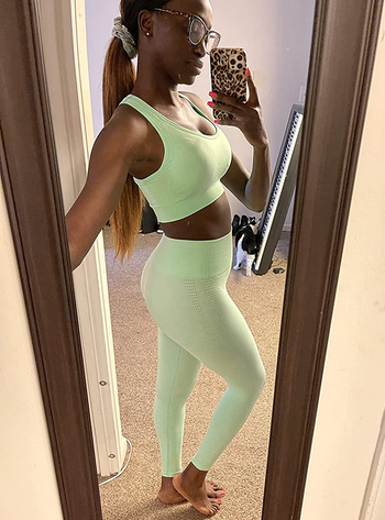 reviewer wearing the green bra and leggings set