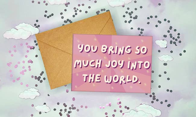 pink greeting card with yellow stars and white bubble text that reads you bring so much joy into the world