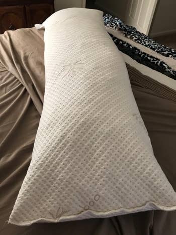 reviewer image of the white body pillow on brown sheets