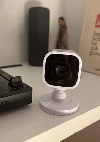 a reviewer photo of the small camera in white 