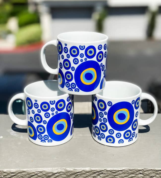 Three mugs stacked on each other covered in evil eyes of various sizes