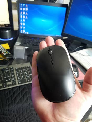 Reviewer's hand holding wireless mouse