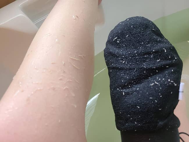 a reviewer photo of the mitt covered in dead skin after use on leg
