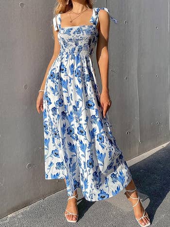 model in a sleeveless blue and white floral maxi dress with tie-up straps and white sandals