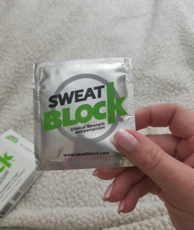 reviewer holding sweatblock wipe packet 