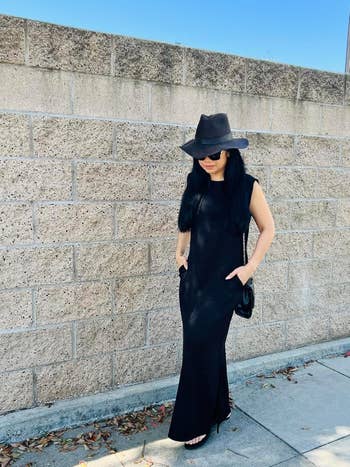 Person successful  a minimalist sleeveless formal  and wide-brimmed hat, walking on  a chromatic  wall, hands successful  pockets, stylish and casual