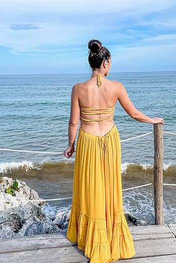 reviewer showing the open back of the dress in yellow