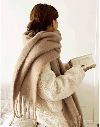 Model in giant oversized camel colored scarf with frayed edges 