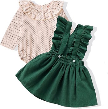 a green flutter sleeve overall dress and a pale pink ruffled shirt with tiny black polka dots