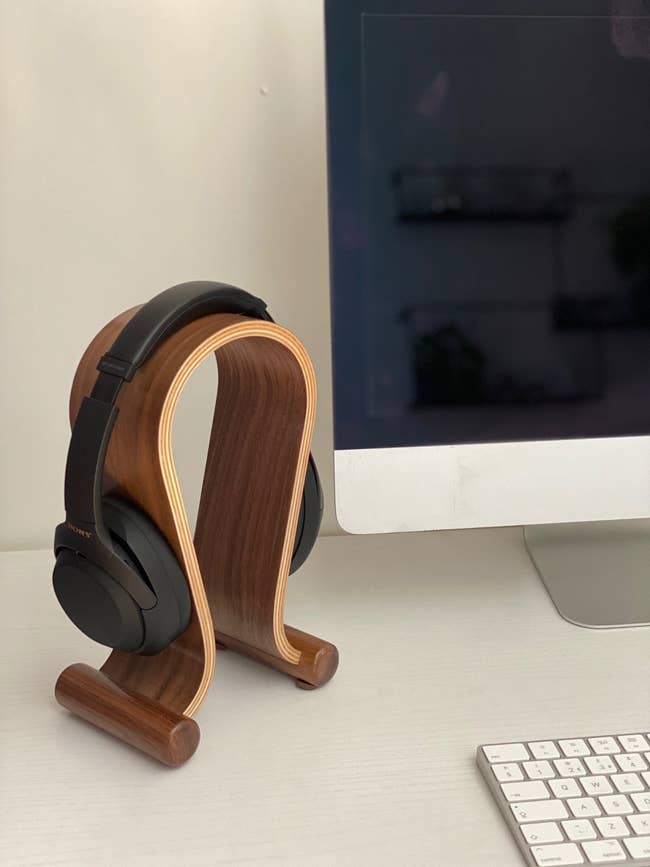 the dark natural wood holder with headphones on it