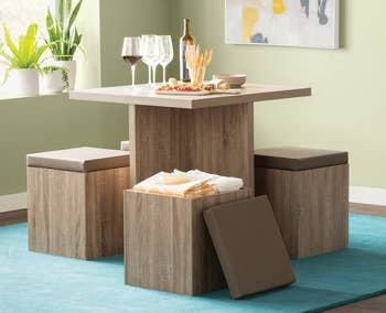 brown five-piece dining set with four stools around the table and one opened to reveal hidden storage