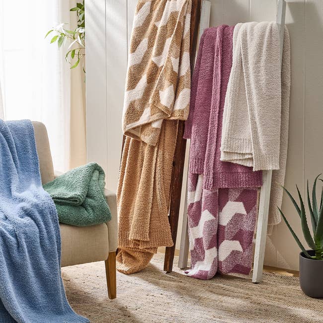 Cozy knitted blankets successful assorted patterns and textures are draped implicit a ladder and seat successful a well-lit country with a works nearby