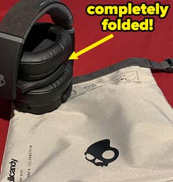 a reviewer shows the folded headphone next to the carrying case