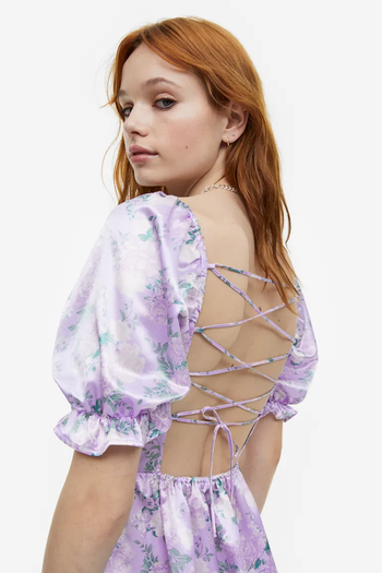 a model showing a lace-up open back dress