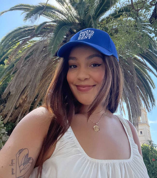 model wearing blue baseball cap embroidered with 