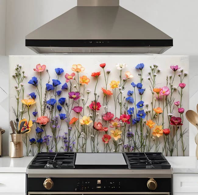 Kitchen with a modern stove and vent hood, featuring a decorative floral backsplash with assorted flowers lasting upright