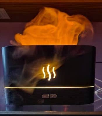 still image showing fake flames emerging from the black humidifier 