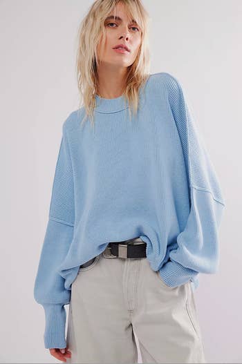 Model in an oversized knit blue crewneck
