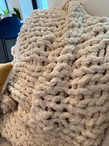 a reviewer showing the hand knit blanket up close