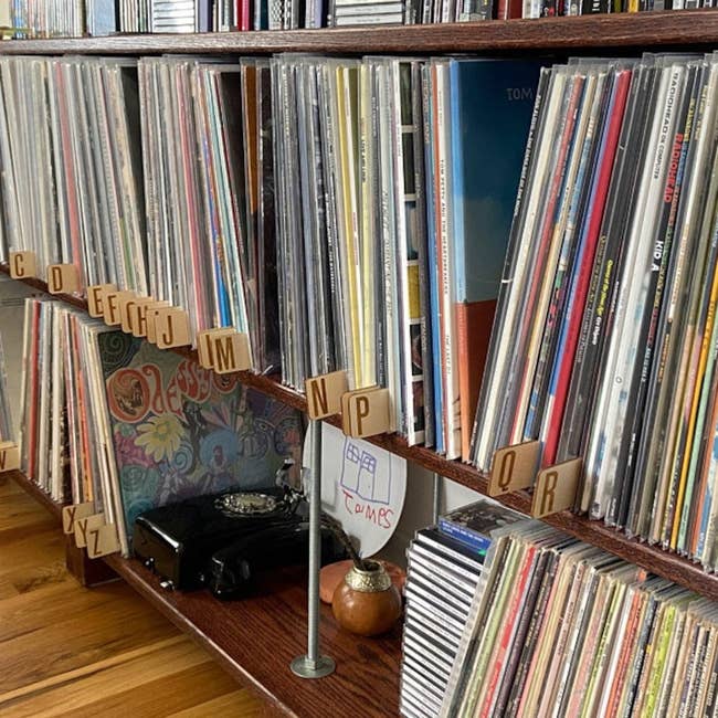 a shelf full of records with the wooden dividers separating them