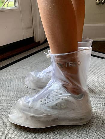 reviewer wearing the clear show covers over their white sneakers