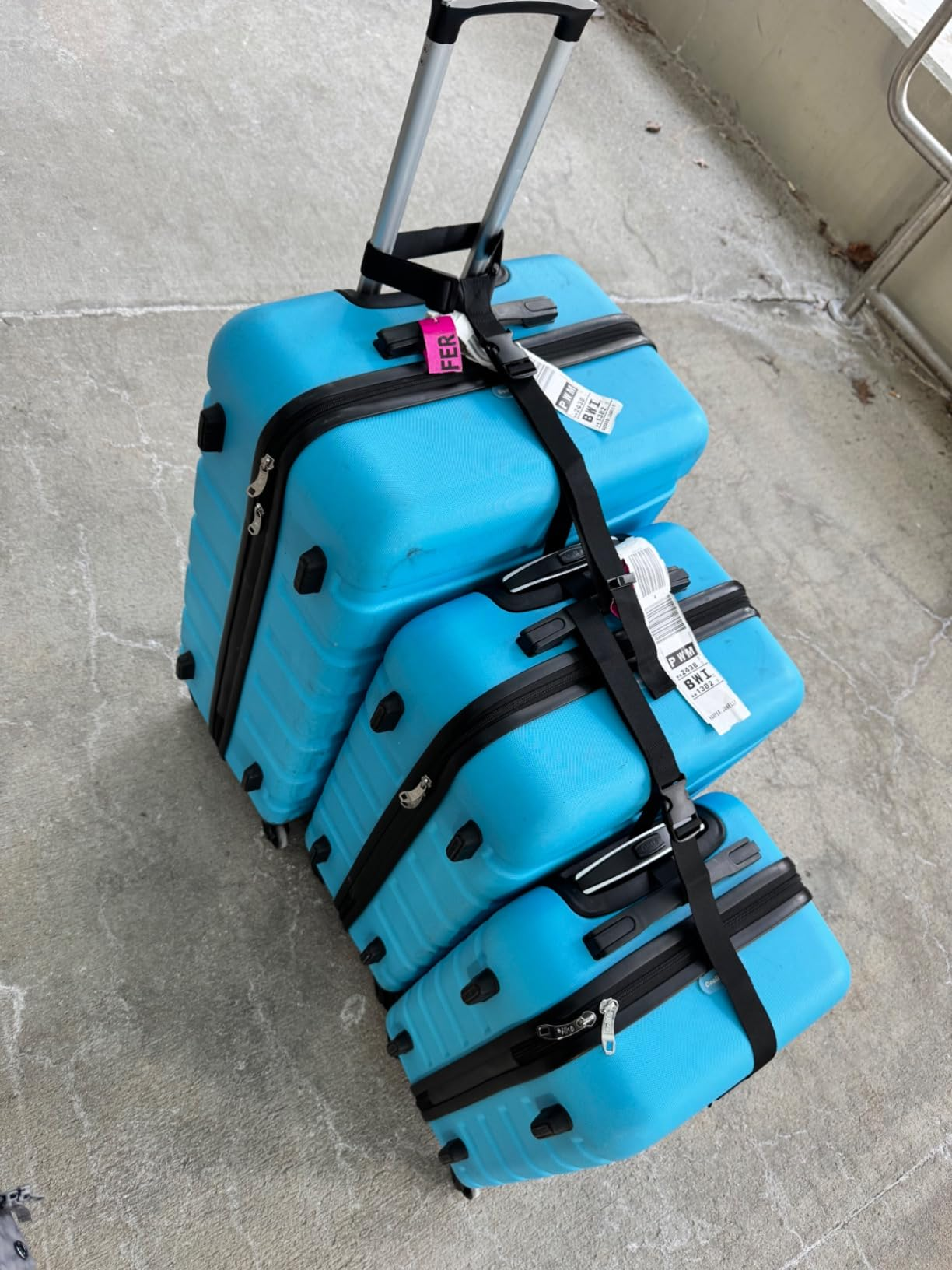 Three suitcases attached together by the strap 