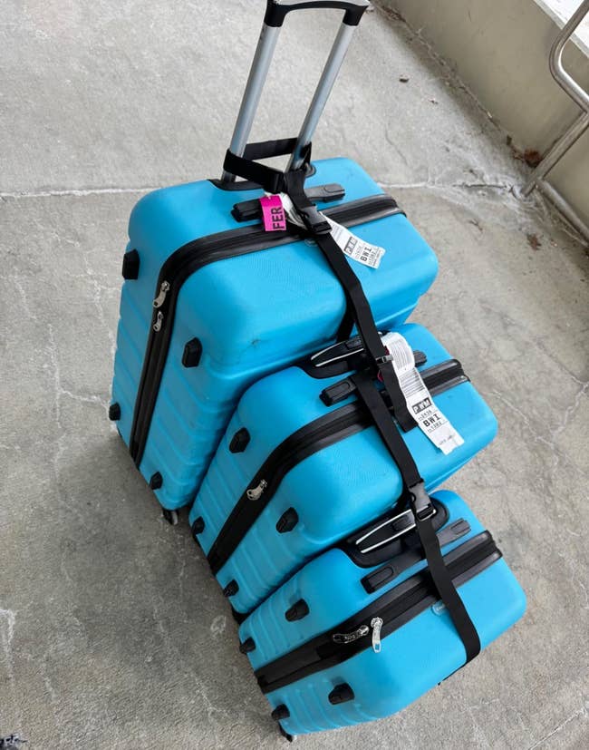 Three suitcases attached together by the strap