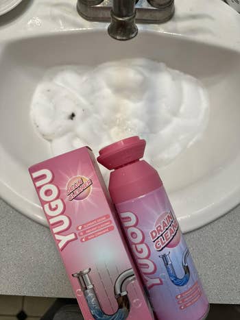 Yugou drain cleaner vessel  and container  connected  a bath  sink, foam successful  the drain suggests progressive  use