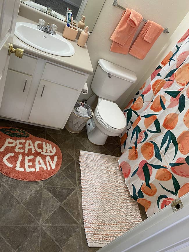 reviewer's bathroom with the peach-shaped bath mat that says 