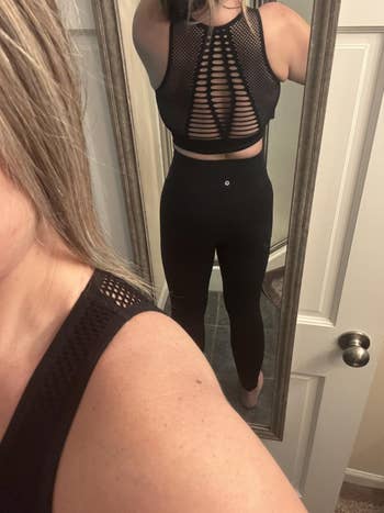Woman successful reflector selfie wearing a stylish achromatic workout outfit with a mesh-back design