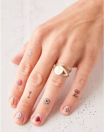 Model with tiny tattoos on their fingers 