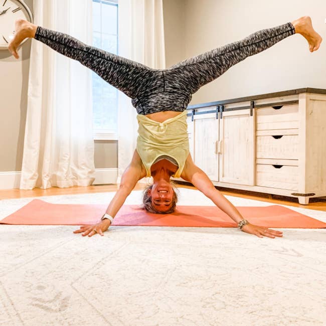 reviewer doing a headstand wearing the gray and black leggings