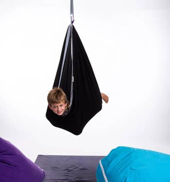 child hanging in sensory swing