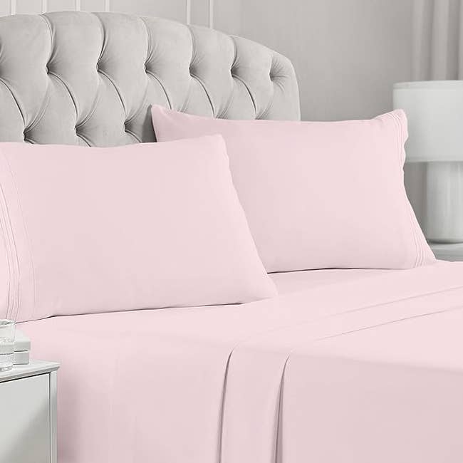 The pink four piece sheet set on a bed