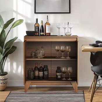 Home barroom setup with assorted bottles, glasses, and plants; modern furnishings portion suitable for enhancing location decor