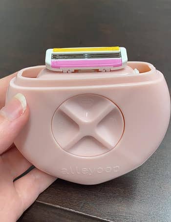 A pink round handled portable razor 